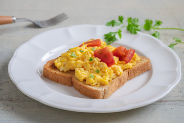 Scrambled eggs with tomato on toasted whole wheat bread