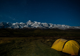 Fototapeta na wymiar yellow tent at night on the background of a mountain range, stars, dark, Altai