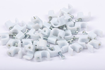 Close up of Plastic cable clips with galvanized steel nails on white background