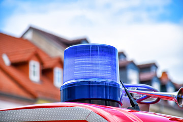 Detailed view of a blue rotating beacon on the roof of a red fire truck