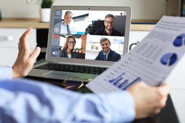 Business woman talking to her colleagues in video conference. Business team working from home using laptop.