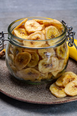 Healthy snack, crispy dehydrated unsugared banana chips in glass jar
