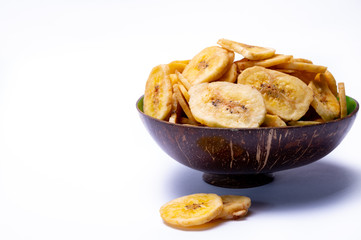 Healthy snack, crispy dehydrated unsugared banana chips in bowl on white background