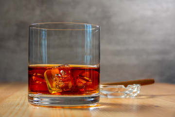 Ashtray With a Cigar and Highball of Whiskey With Ice Cubes