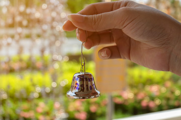 hand holding bell on green background