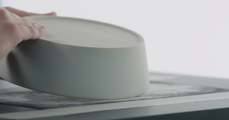 man hands check bottom of white ceramic bowl
