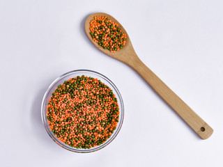 Top view of red lentils and green mung bean in a bowl on a white background. Close-up. Vegan.