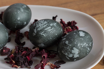 painted Easter eggs dark with spots on a white plate