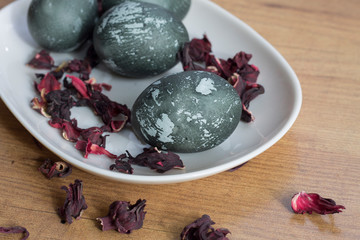 painted Easter eggs dark with spots on a white plate