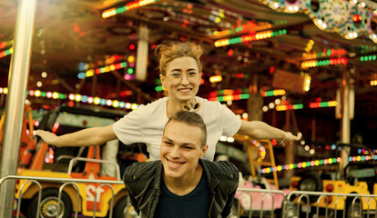 Fototapeta na wymiar Young couple in love having fun together at amusement park Holidays, love and friendship concept