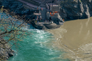 Confluence of muddy colored Alakananda and green colored Bhagirathi river to form Ganges at Devprayag, Uttarakhand, India. This point is known as Sangam & people offers prayers at temple built here. © deepshikha