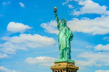 Fototapeta premium The Statue of Liberty on a background of blue sky with white clouds in New York, USA