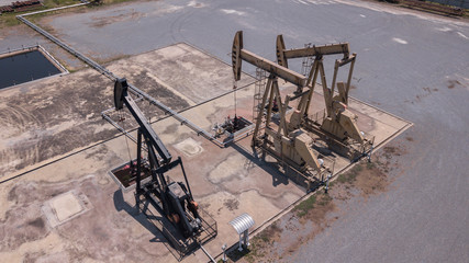 Pumpjack ndustrial oil pump jack working and pumping crude oil for fossil fuel energy with drilling rig in oil field
