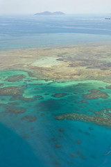 Island in Great Barrier Reef Blue Sea view. Beautiful aqua & turquoise waters, with sand, coral reef patterns in the ocean. View from helicopter, on vacation. Tropical, paradise, holiday concepts