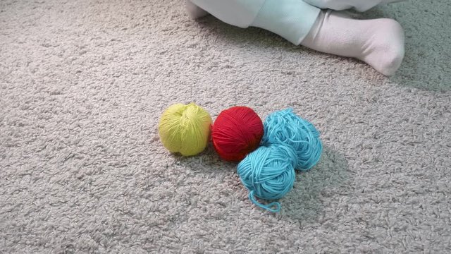 Woman's hands put balls and skein of yarn of different colours