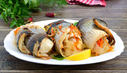 Baked herring stuffed with vegetables. Tasty fish rolls.