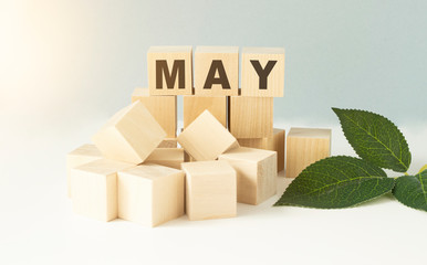 The word May on wooden cubes. Concept Month of year.