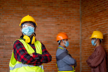 Fototapeta premium Group of professional engineering team wear protective face masks safety for Coronavirus Disease 2019 (COVID-19) at machine industrial factory.