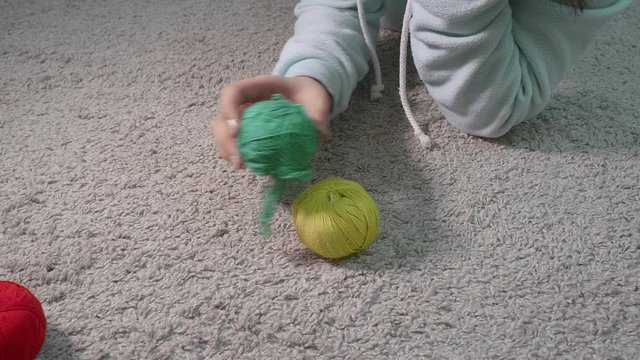 Close up od woman's hands playing with colourful balls of yarn. Coing crazy during quarantine.
