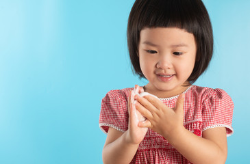 Cute Asian girl washing hands with soap bubbles to kill bacteria COVID - 19 for good health with fun and happiness. With copy space.