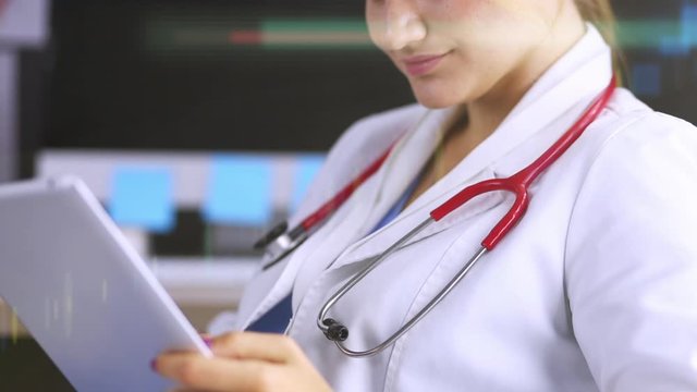 Female Doctor Use A Digital Tablet And Smile To You In Medical Ofice