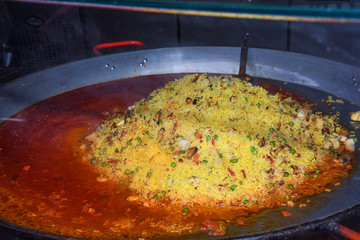 Seafood paella cooked in a large pan wok