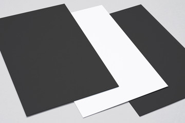 Close view of black and white business cards, flyer, poster isolated on grey to showcase your presentation.