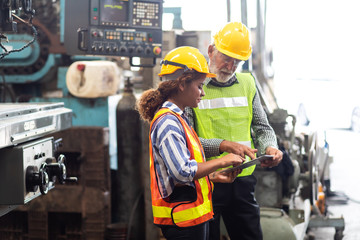 Professional Mechanical Engineer team Working on Personal Computer at Metal lathe industrial manufacturing factory. Engineer Operating  lathe Machinery. Product quality Inspection