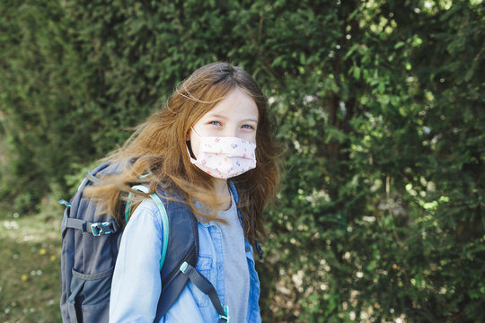 pretty girl with nose mouth mask and school bag goes to school after corona quarantine