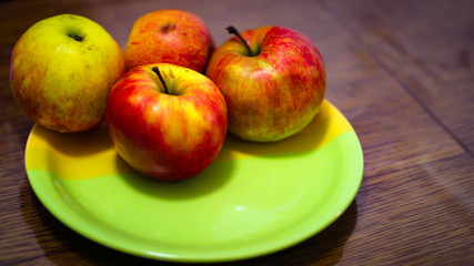 Four Ripe Red And Green Apples Are On The Plate