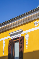yellow colored building with white ornaments on the facade in Pula, Istrian Peninsula in Croatia - obrazy, fototapety, plakaty