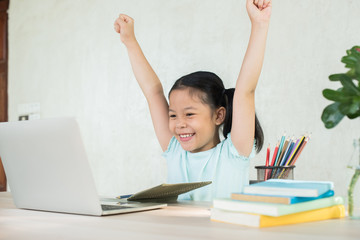 pretty  stylish schoolgirl studying homework during online lesson at home, social distance during...