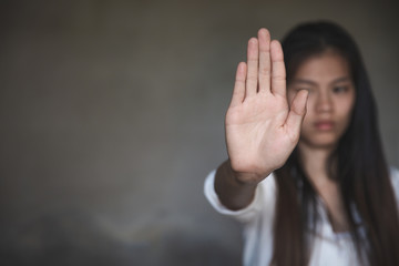 Woman's hand extended signaling to stop useful to campaign against violence, gender or sexual...