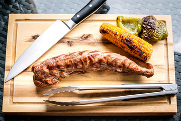 Schweinefilet, Mais, Paprika, Holzbrett, Messer und Grillzange