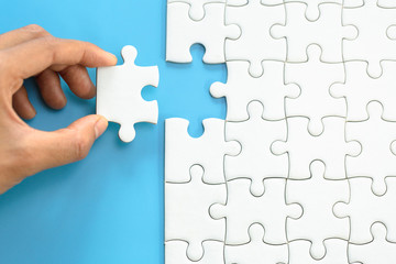 White jigsaw in the hands, The correct solution. Teamwork, Solving and completing the task. Last...