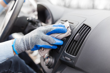 Auto service staff hand cleaning car interior with microfiber cloth. Car detailing and valeting concept
