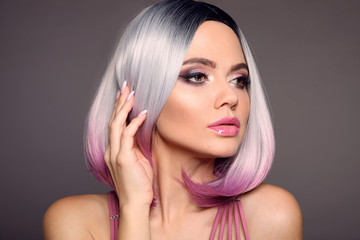 Beauty Portrait of woman with Ombre bob short hairstyle. Beautiful coloring  hair. Trendy puprle haircut. Blond model with short shiny haircuts isolated on grey Background. Makeup. Manicured nails. © Victoria Andreas