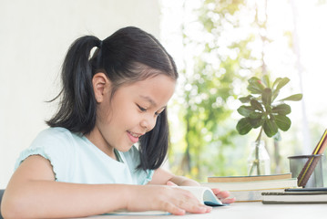 pretty stylish schoolgirl studying homework during online lesson at home, social distance during quarantine, self-isolation, online education concept, home school. girl does homework in her copybook