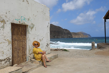 mujer con sombrereo amarillo y vestido amarillo sentada casa playa mediterraneo almería ...