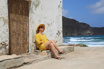 mujer con sombrereo amarillo y vestido amarillo sentada casa playa mediterraneo almería ...