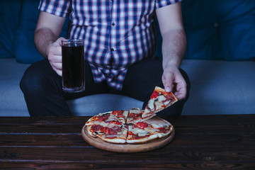 Emotional eating, food delivery, depression, loneliness, stress. Fat overweight man sit on the coach with beer and pizza