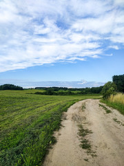 Scenic View Of Road Amidst Field Against Sky