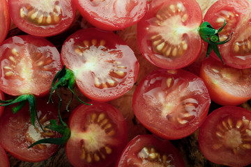 Sliced fresh organic season's cherry tomatoes on a wooden table.