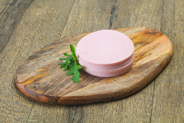 Sliced sausage over the wooden board