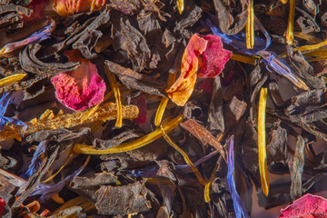 Background with scattered ready-made mixture with dry herbs for fruit and flower tea at high magnification