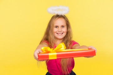 Portrait of generous delighted child girl with long blond hair and angelic halo holding gift box...