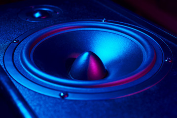 Sound audio speaker with neon lights on dark background. Dynamic monitor close up. Creative backgroound