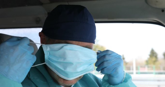 Ambulance Medical Driver Wears A Medical Mask. Driver Wearing An Anti-virus Mask Protecting Others Against COVID-19 And SARS Cov 2 Crown Infection