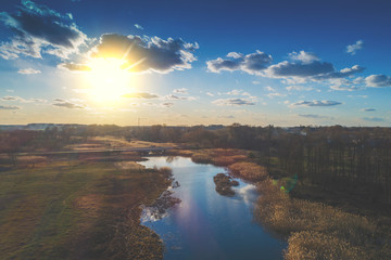 Aerial view of countryside and brook in evening at sunset light. Beautiful rural nature landscape