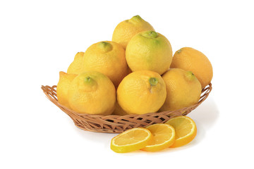 Lemons in wicker basket with slices isolated on white